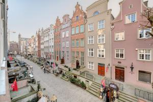 a city street with buildings and people walking on the street at Apartamenty Mariacka in Gdańsk