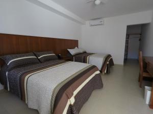 twee bedden in een hotelkamer met bij Hotel Santiago in Jalpan