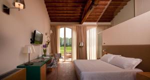 a bedroom with a bed and a television in a room at Locanda Sant'Agata in San Giuliano Terme