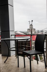uma mesa e cadeira numa varanda com vista em Iberia Palace Hotel em Zugdidi
