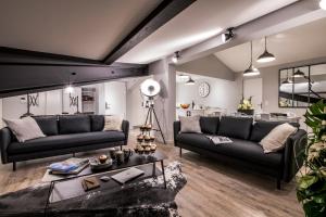 uma sala de estar com dois sofás pretos e uma mesa em Résidences Alticimes em Brides-les-Bains