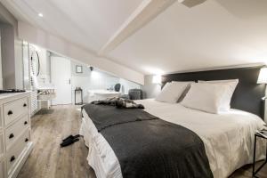 um quarto com uma grande cama branca e uma casa de banho em Résidences Alticimes em Brides-les-Bains