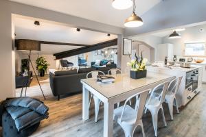 a kitchen and living room with a white table and chairs at Résidences Alticimes in Brides-les-Bains