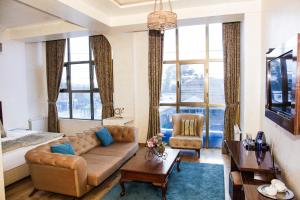 uma sala de estar com um sofá e uma grande janela em Iberia Palace Hotel em Zugdidi