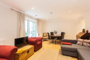 a living room with a couch and a tv and a table at Superior 2 Bedroom apartment St Paul's City of London in London