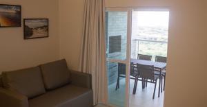 a living room with a couch and a table and a balcony at Salinas Park Resort in Salinópolis