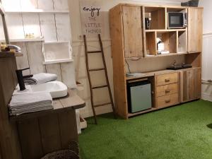 een kamer met een keuken met een bureau en een ladder bij B&B Usselo Klein, fijn en uniek! in Enschede
