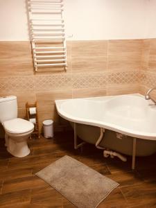 a bathroom with a bath tub and a toilet at Józka Chata max 15 os sauna in Porąbka