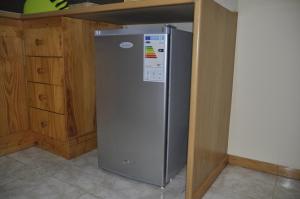 einen Kühlschrank aus Edelstahl in einer Küche mit Holzschränken in der Unterkunft Apartamento Ferradura in Espargos
