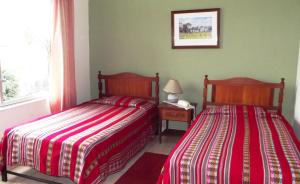 two beds sitting next to each other in a bedroom at Hostal Gemina in Lima
