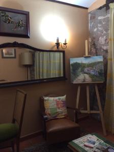 una habitación con una pintura en un caballete y una silla en Cal Pons, en Prades