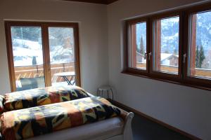 Schlafzimmer mit einem Bett und Fenstern mit Aussicht in der Unterkunft Chalet du Chef in Grächen