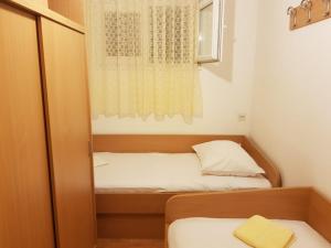a small bedroom with a bed and a window at Apartman Nino in Okrug Donji