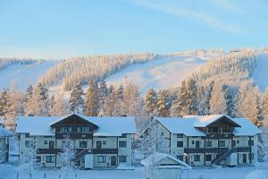 un complejo con árboles nevados y una pista de esquí en Apartments Anna, en Tahkovuori