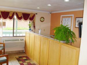 a kitchen with a bar and a window with a fan at Stagecoach Inn Motel in Molalla