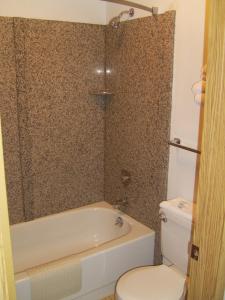 a bathroom with a toilet and a tub and a sink at Stagecoach Inn Motel in Molalla