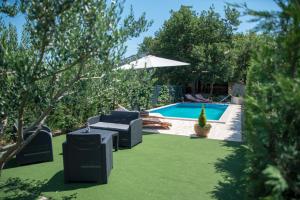a backyard with a swimming pool and green grass at Holiday Home Zavala in Klek