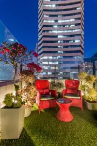 a patio with chairs and a table and a building at Hotel Regina in Bogotá