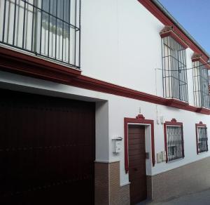 un edificio con garaje y puerta roja en APARTAMENTO EN OLVERA CON GARAJE, en Olvera