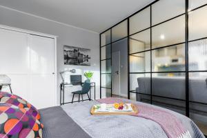 een slaapkamer met een dienblad met eten op een bed bij Ideal Apartments Green & Blue in Gdańsk