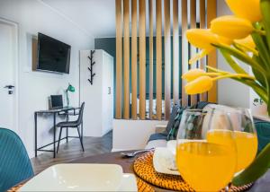 een woonkamer met een tafel met gele glazen erop bij Ideal Apartments Green & Blue in Gdańsk