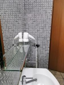 a bathroom with a sink and a white tiled wall at Ahr Hotel Antille in Cazzago di Pianiga