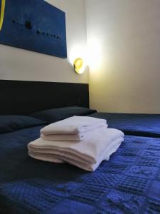 a pile of towels sitting on top of a bed at Hotel The Click - Art & Colors in Cazzago di Pianiga