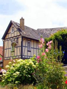 a white and blue house with flowers in front of it at Landhotel Nonnenroth in Hungen