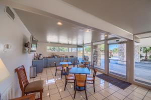 a room with tables and chairs and a kitchen at Americas Best Value Inn Uvalde in Uvalde