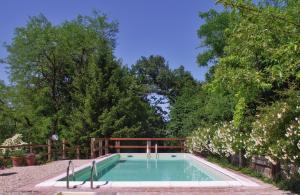 a swimming pool in a garden with trees at La Traversina in Stazzano
