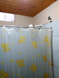 a shower curtain with yellow flowers on it in a bathroom at La Casa Maruja in Lima