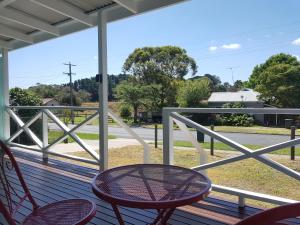 a porch with chairs and a table and a view of a street at Fish Creek Adrift Accommodation in Fish Creek