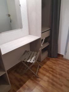 une chaise placée sous un bureau avec un miroir dans l'établissement Heliopolis F39, au Cap d'Agde