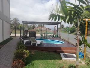 a swimming pool in a yard with a chair at Pousada Caminho do Porto in Pecém