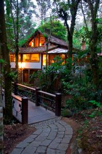 une maison avec une terrasse en bois dans les bois dans l'établissement Pousada Casa Bonita, à Visconde de Mauá