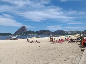 un grupo de personas sentadas en una playa en Quarto Masculino Compartilhado em Santa Teresa, en Río de Janeiro