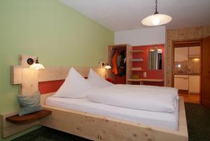 a bedroom with a large bed with white sheets at Appartement Ambrosius in Lermoos