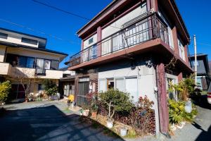 une maison avec un balcon sur le côté de celle-ci dans l'établissement Habitacion NIIYA Mt Fuji, à Fujikawaguchiko