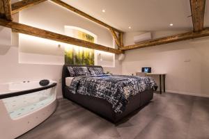 卢布尔雅那Gami Ex-Factory Lofts的一间卧室设有一张大床和一个浴缸 更多194张照片