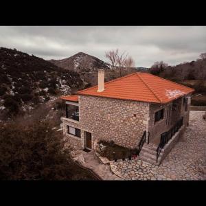 a brick house with an orange roof on a hill at Villa Agno - Βίλα Αγνώ in Ãno KariaÃ­