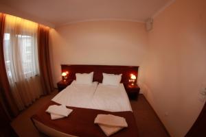a bedroom with a bed with white sheets and pillows at Downtown Bansko Resort in Bansko