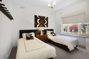 a bedroom with two beds and a window at The Beach House Apartment in Geelong