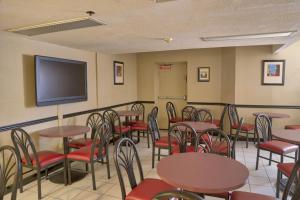 a restaurant with tables and chairs and a flat screen tv at Destiny Palms Hotel Maingate West in Kissimmee