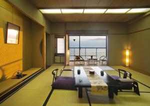 a living room with a table and a view of the ocean at Genjiko in Minamichita
