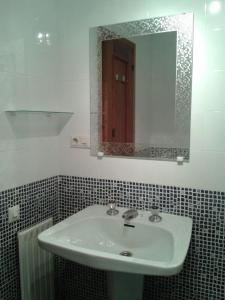 y baño con lavabo y espejo. en Pensión Room Pamplona, en Pamplona