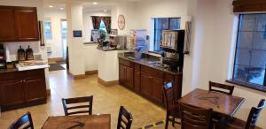 un restaurante con mesas y sillas y una cocina en Howard Johnson by Wyndham Flagstaff University West en Flagstaff