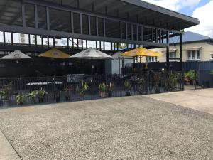 un edificio con mesas y sombrillas delante en Goondihill Hotel en Innisfail