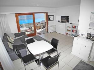 een woonkamer met een bank en een tafel met stoelen bij Pendio del Sole App 3838 in Orselina