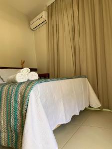 a bedroom with a bed with towels on it at POUSADA Dunas de Marape - Alagoas in Jequia da Praia