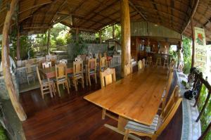 uma sala de jantar com uma mesa de madeira e cadeiras em Hotel Jinetes de Osa em Drake